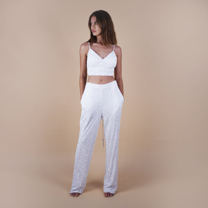 off-white Anastasia Beaded Bralette Crop Top. Handcrafted with intricate beadwork, this versatile party outfit features a lace-up tie closure at the back, ensuring a perfect fit. Stand out at events with this chic and stylish crop top. In movement.