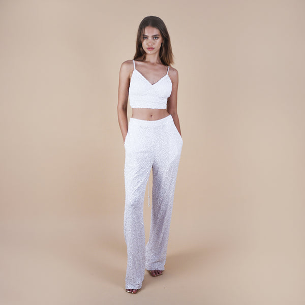 Evan sequin off-white pants are perfect for glamorous nights out, weddings, and special occasions, offering both style and comfort. Elevate your look with these versatile and chic pants. Front view showing the pockets